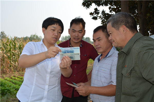 内乡农商行组织人员到田间地头向村民宣传新版人民币知识