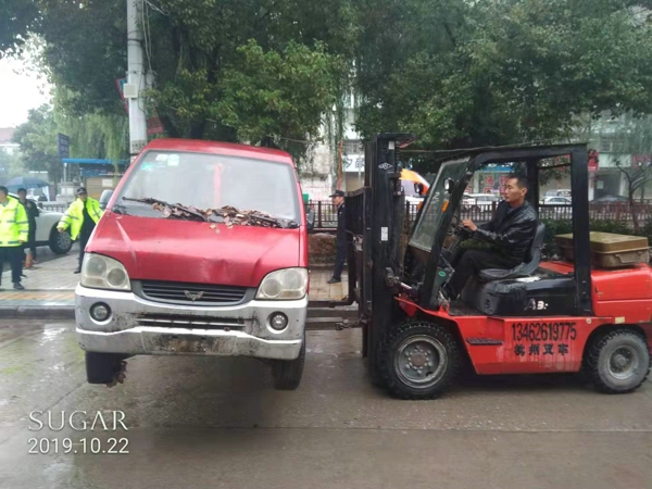 邓州市城市管理警察大队民警冒雨清理城区“僵尸车”还道于民