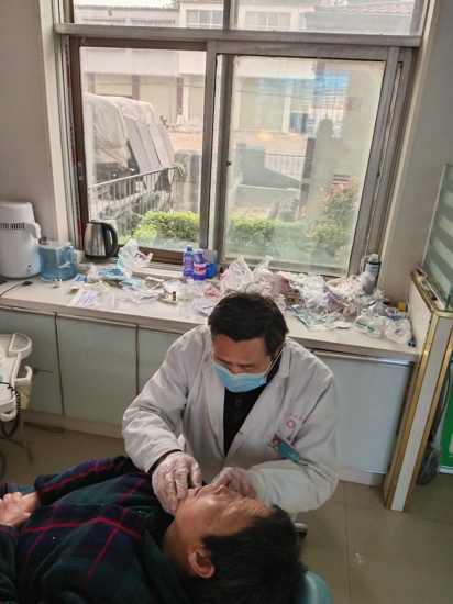 汝南县金铺镇卫生院医师刘延春为学生和家长进行牙齿健康检查