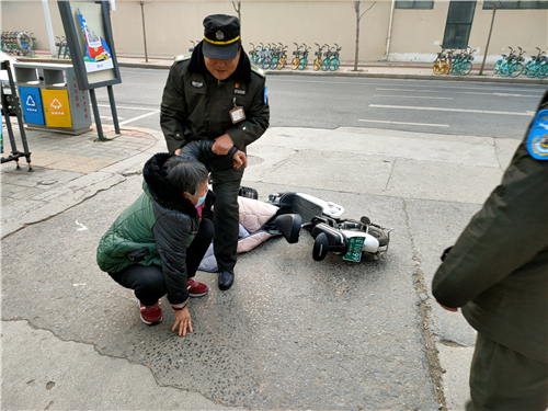 老人骑车下斜坡连人带车栽倒 巡防队员将其扶起