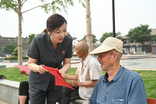 图一：干警向广场群众普及档案知识