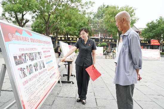 图五：干警向过往群众讲解法院档案相关知识