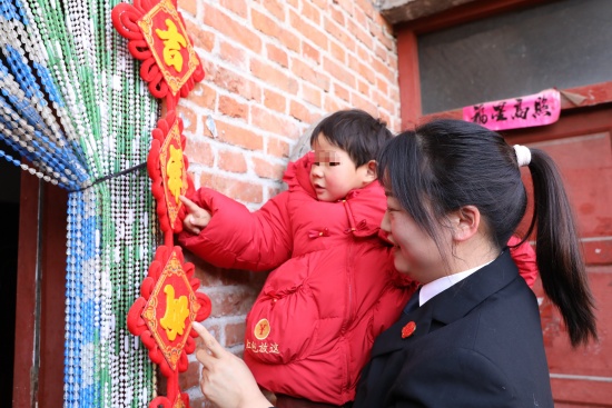 图5为法官和孩子一起挂春联