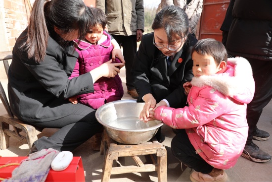 图2为法官为孩子们清洗脸蛋和小手