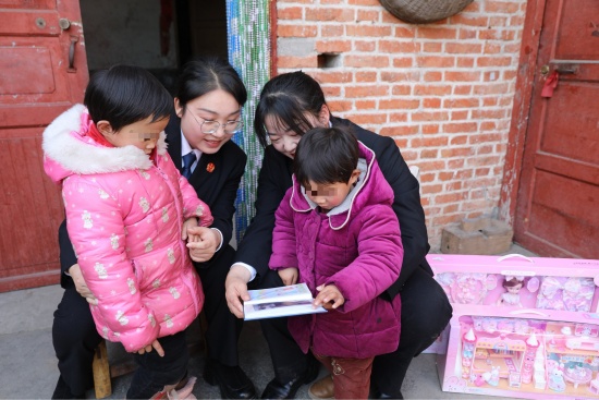 图4为法官为孩子们送上精心制作的相册礼物