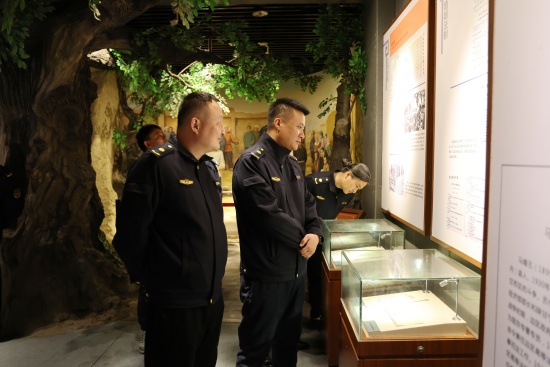 2、城管执法队员驻足仔细观看展布内容和陈列物