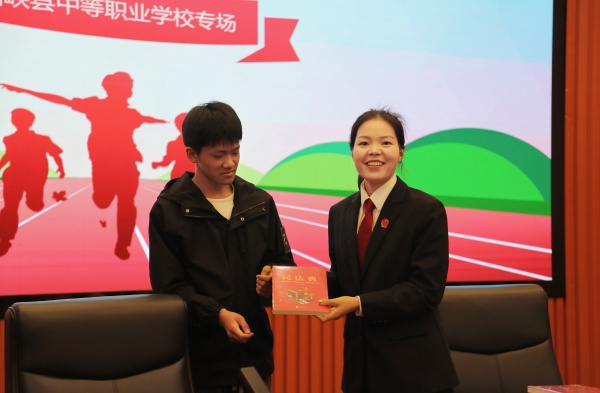 图2为讲座过程中为踊跃回答问题的同学赠送法治教育书籍等奖品